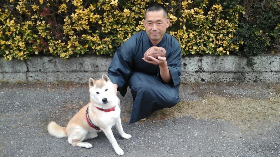 演者の南沢さんの写真です。着物姿で犬を連れています。手にはサツマイモで作った生後間もないウリ坊を抱えています。